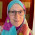 Smiling woman, white skin, turquoise and pink headscarf, glasses